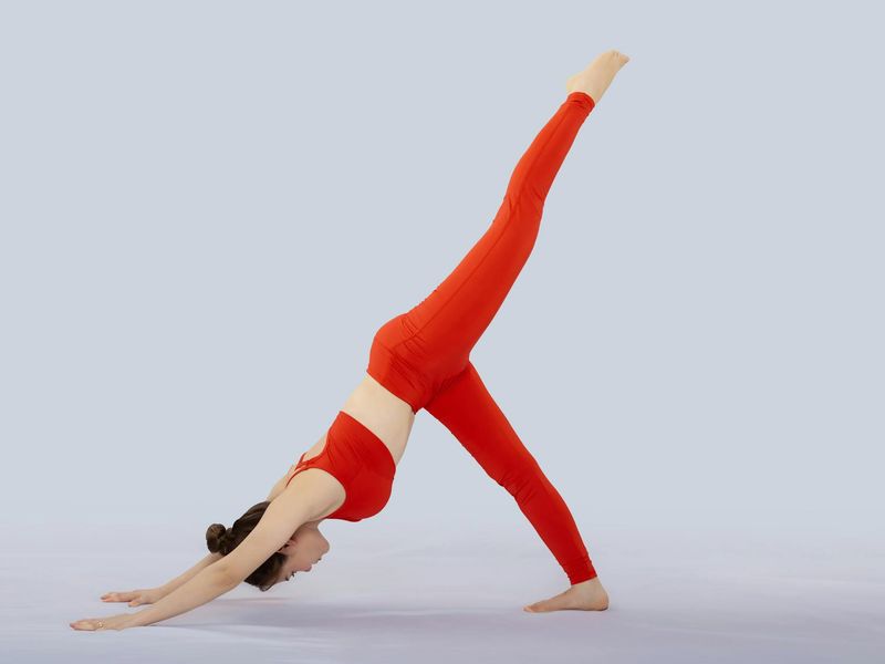 Woman performing a fluid yoga sequence in a calm studio.